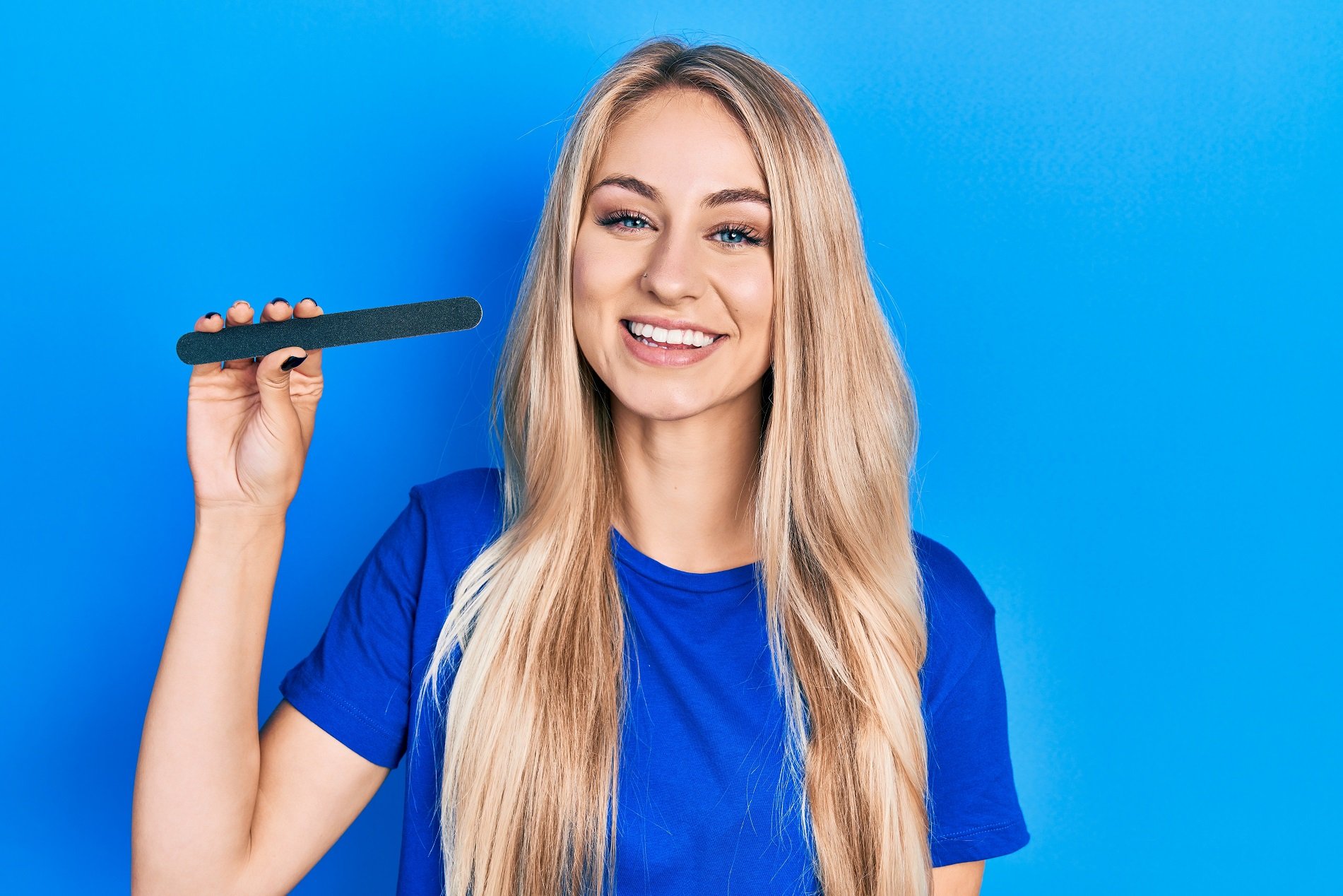 young blonde woman holding nail file