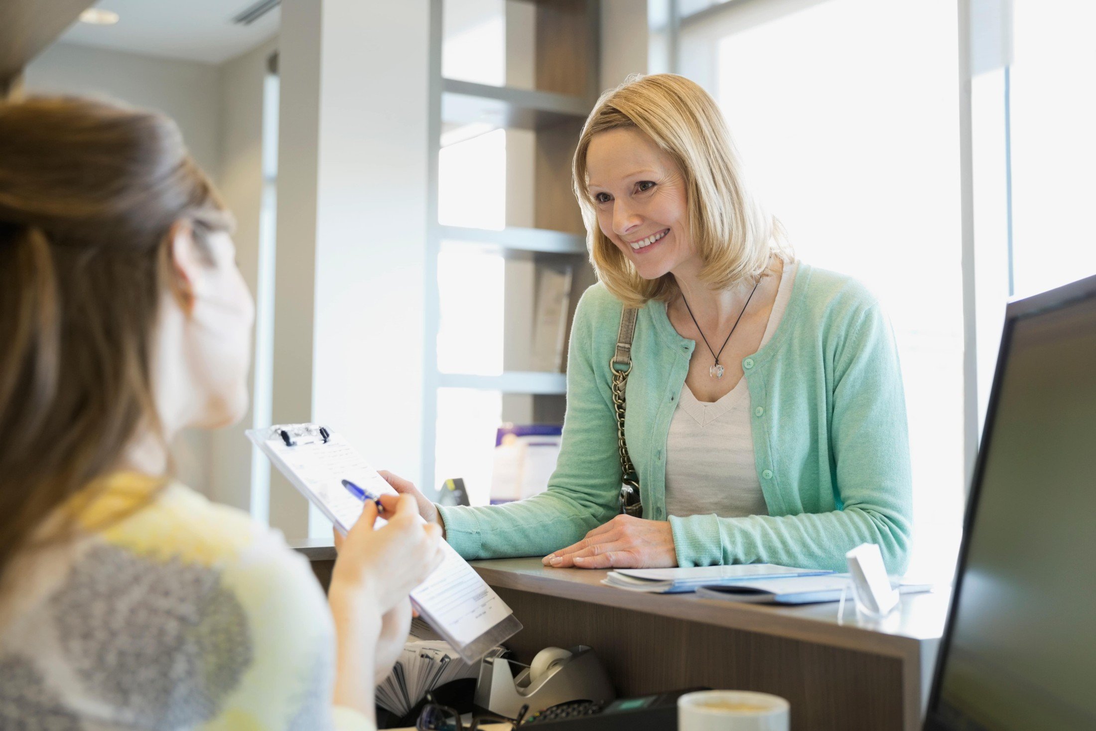 Receptionist Explaining Paperwork Patient Dentists Office